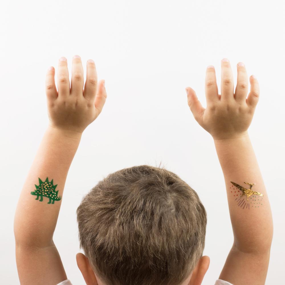 Boy with DInosaur tattoos on armsi