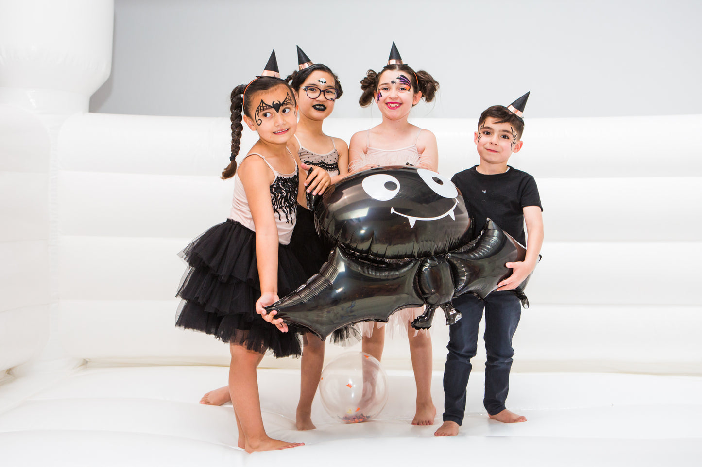 Black Bat foil balloons being held by kids
