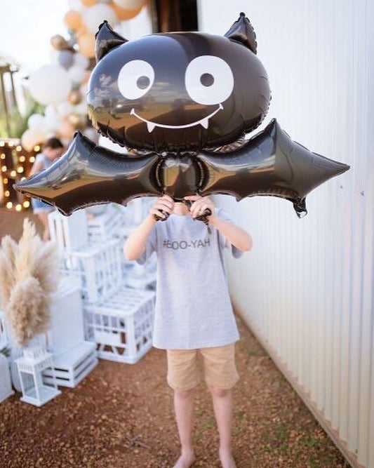 Black Bat Foil Balloon being held up by a child